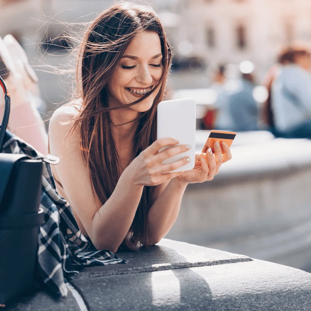 A picture of someone holding a phone and a credit card.