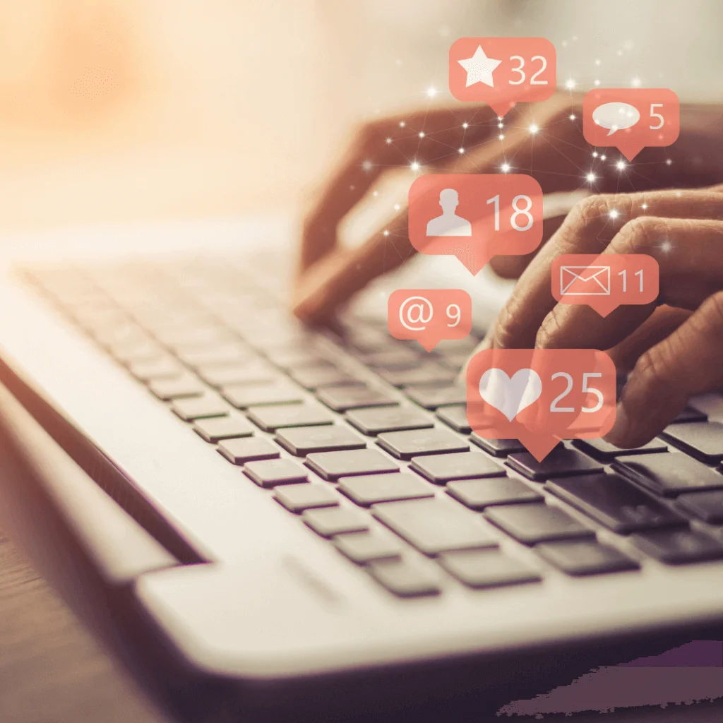 A picture of someone typing on a computer with graphics of social media icons toward the right of the picture.