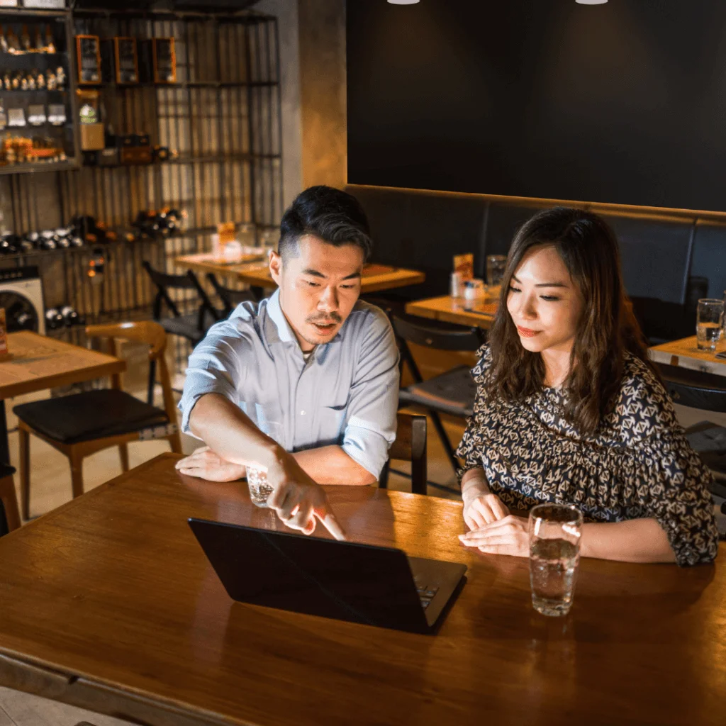 A picture of two business owners over a computer.