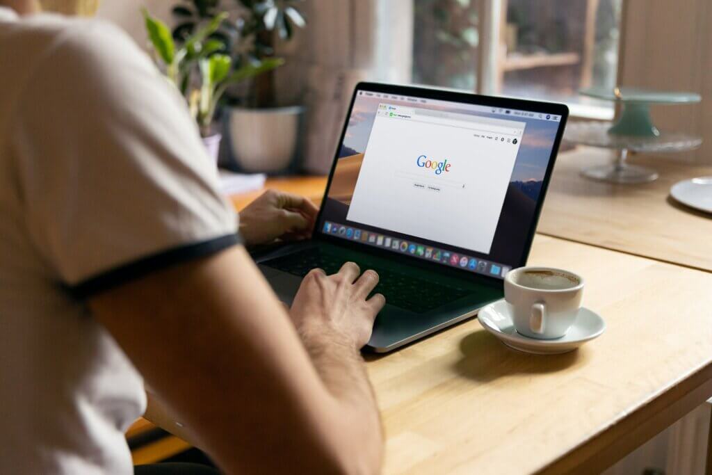 A picture of a person searching on Google at a coffee shop