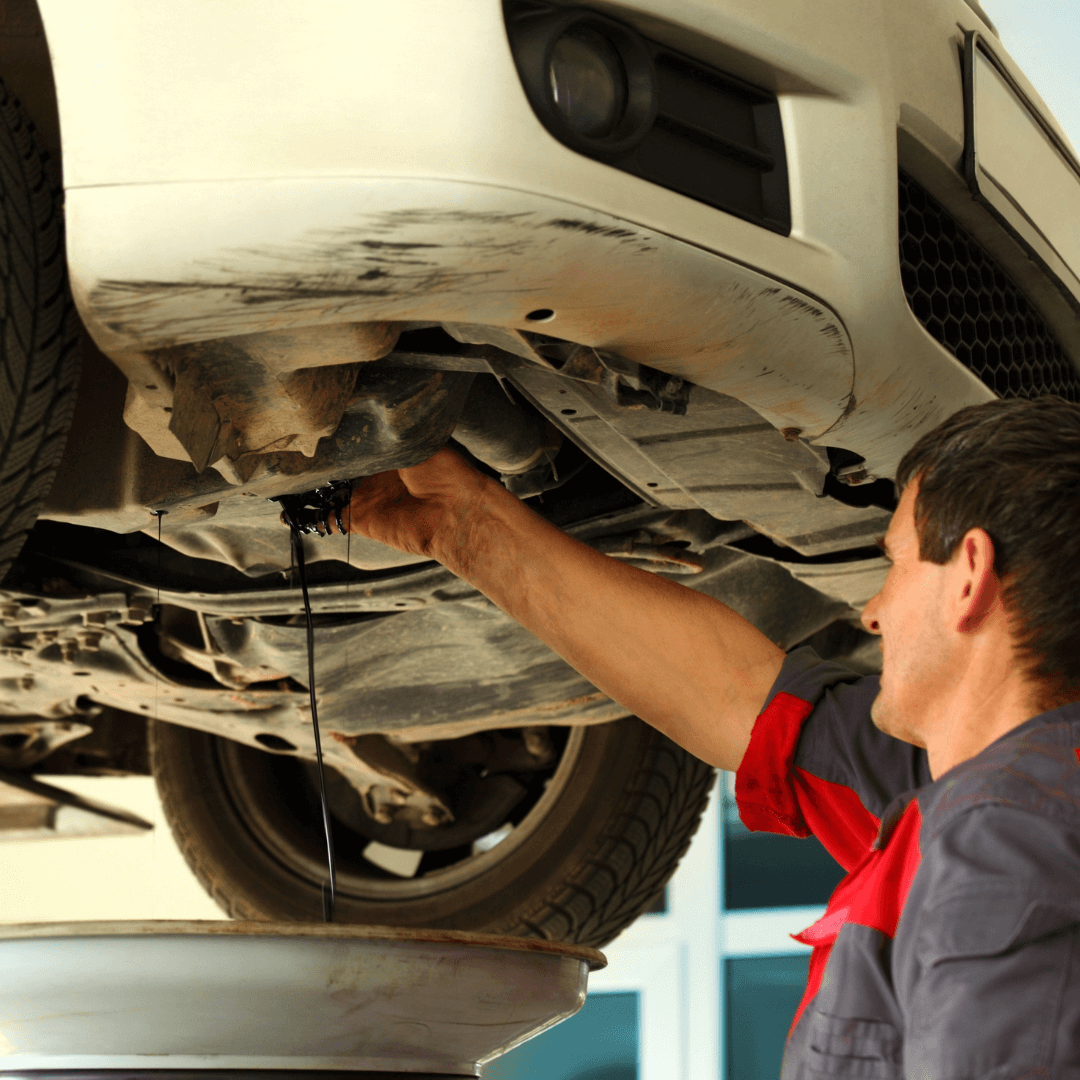 A picture of someone emptying oil from a car.