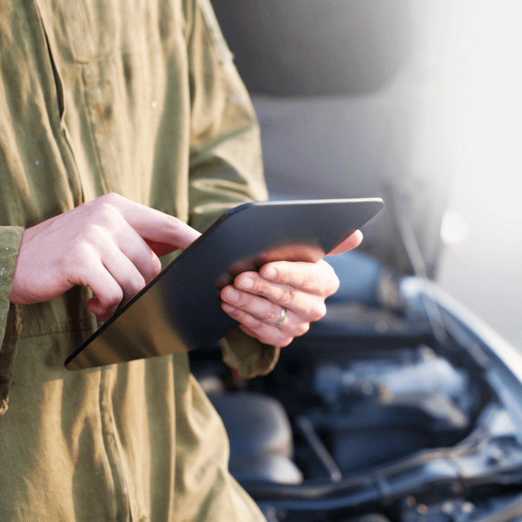 A picture of a mechanic on his tablet.