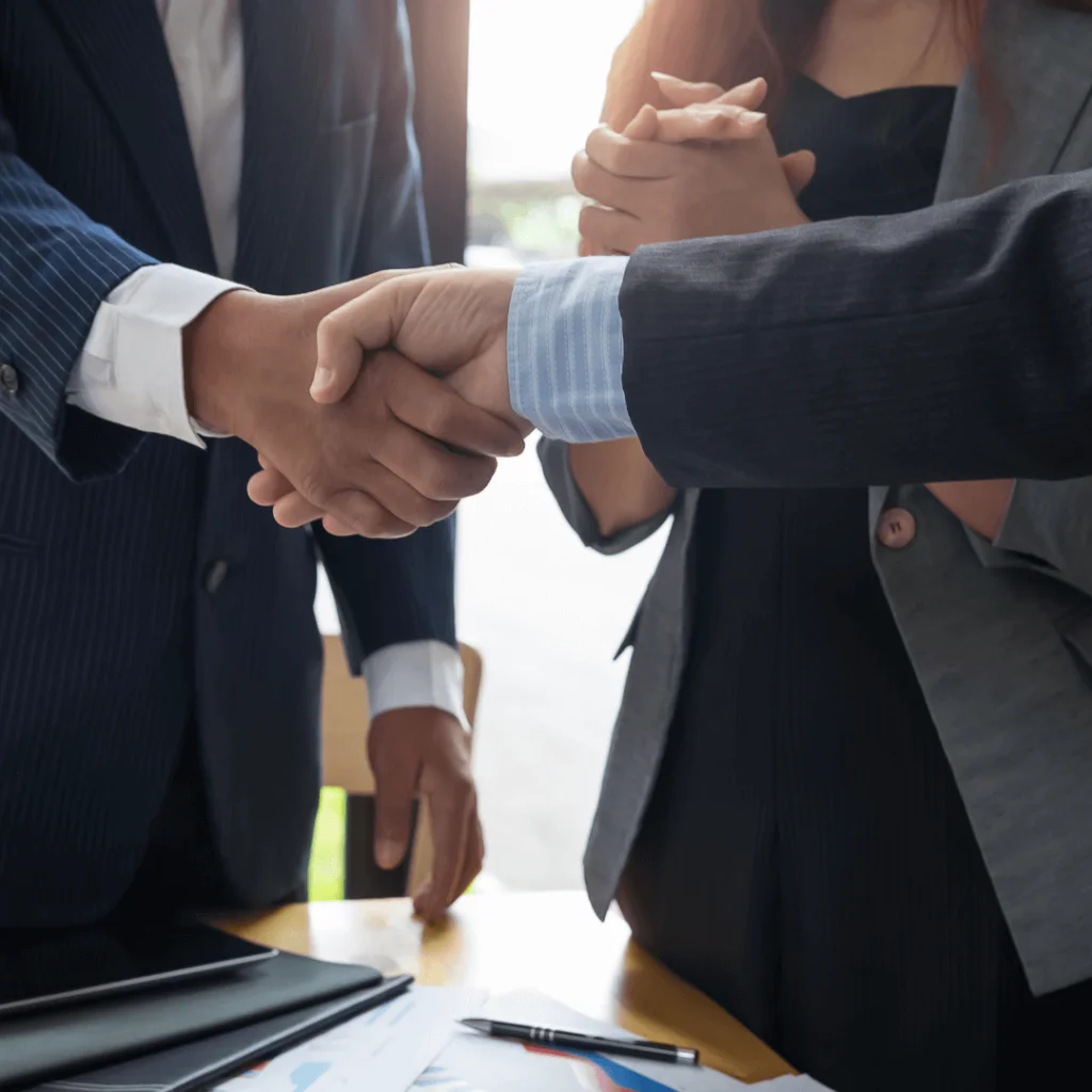 A close-up of two men shaking hands to signify a business transaction