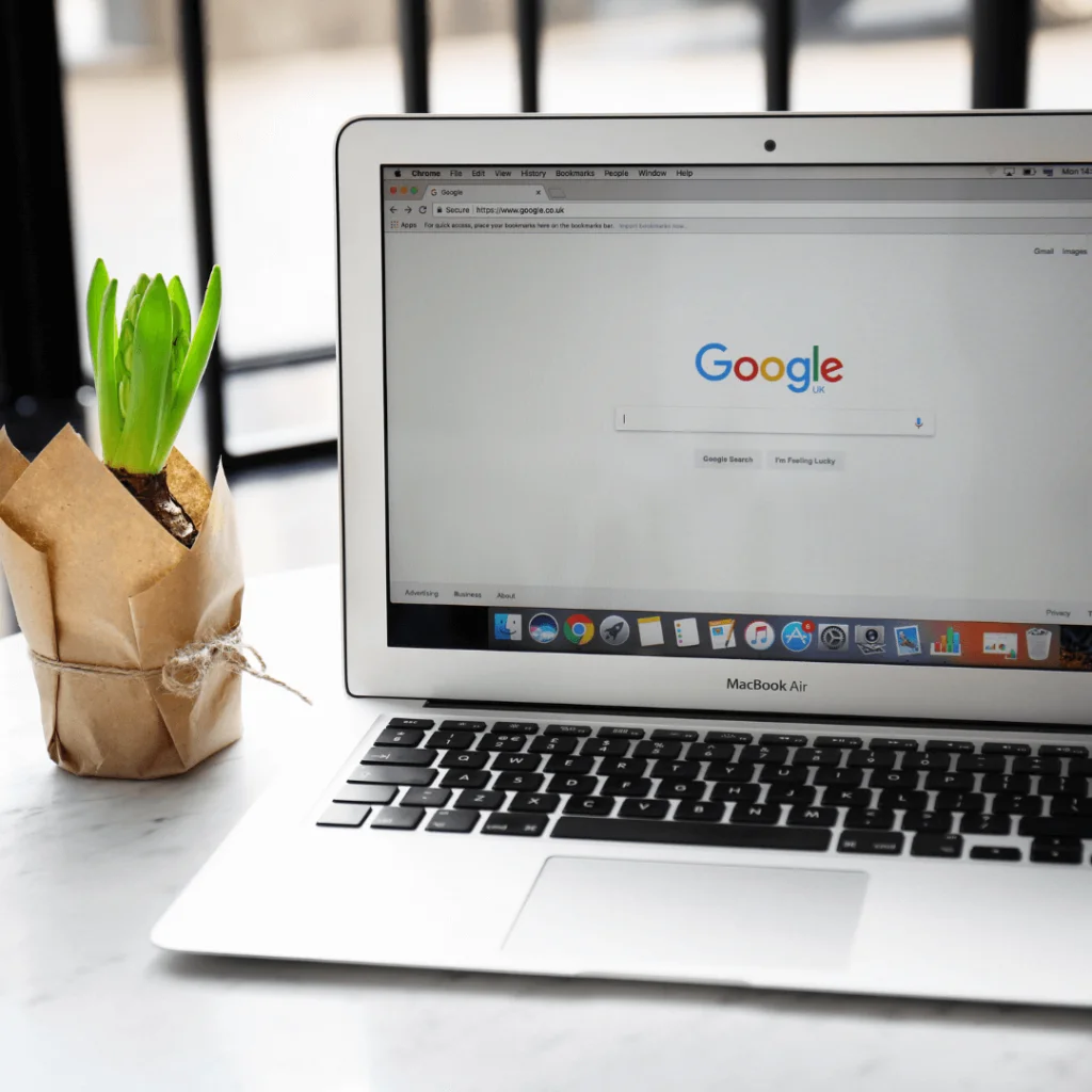 a laptop on a desk with Google pulled up on the screen