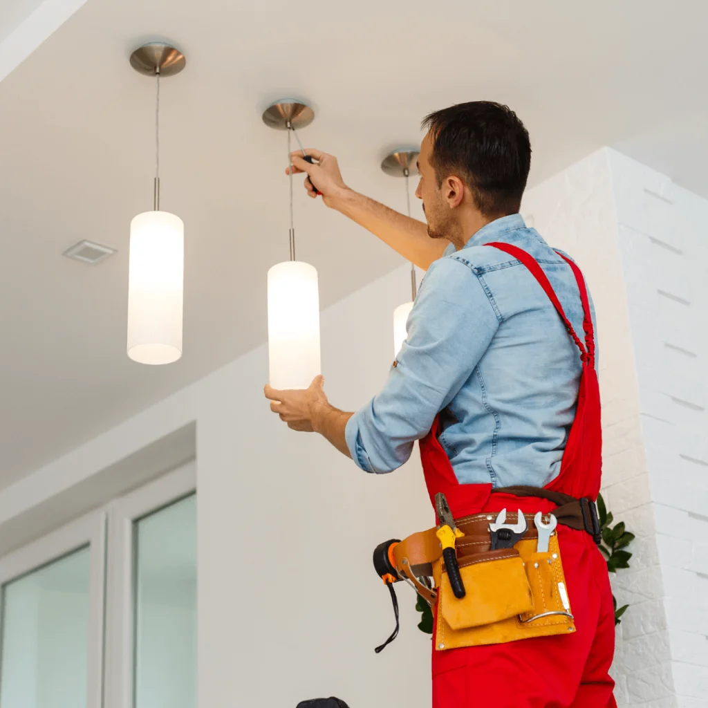 An electrician installing a light fixture