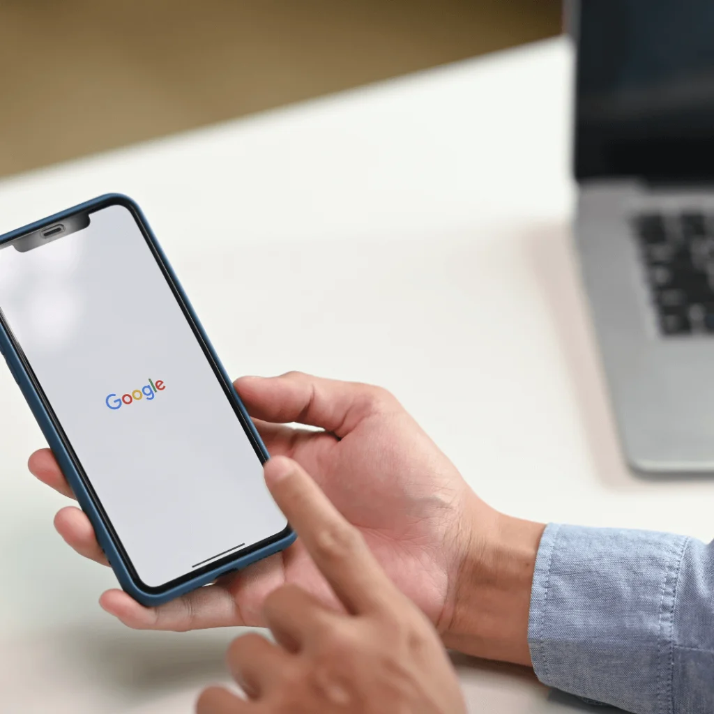 A close-up of someone using Google on their cell phone