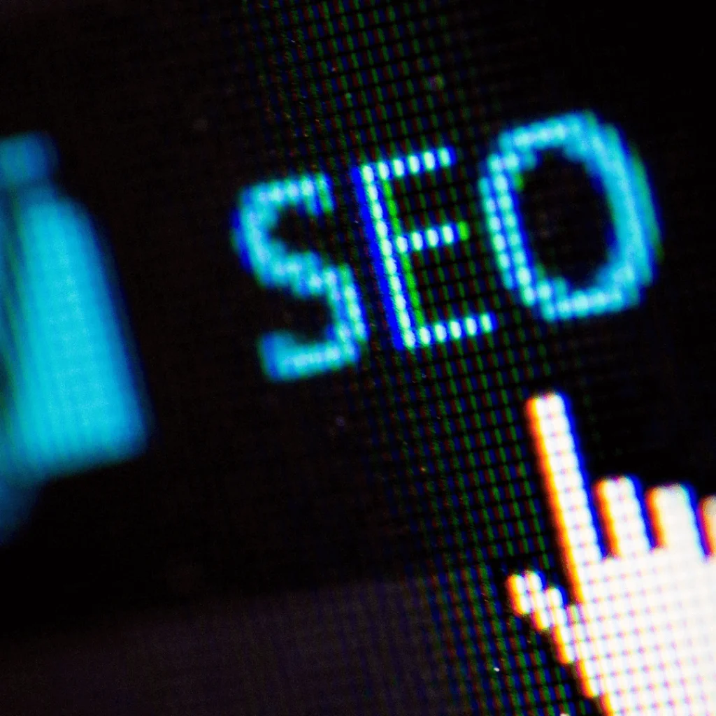 A closeup of a mouse symbol clicking "SEO" on a computer screen