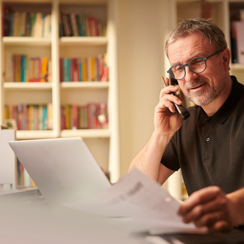 A small business owner is smiling on the phone. 