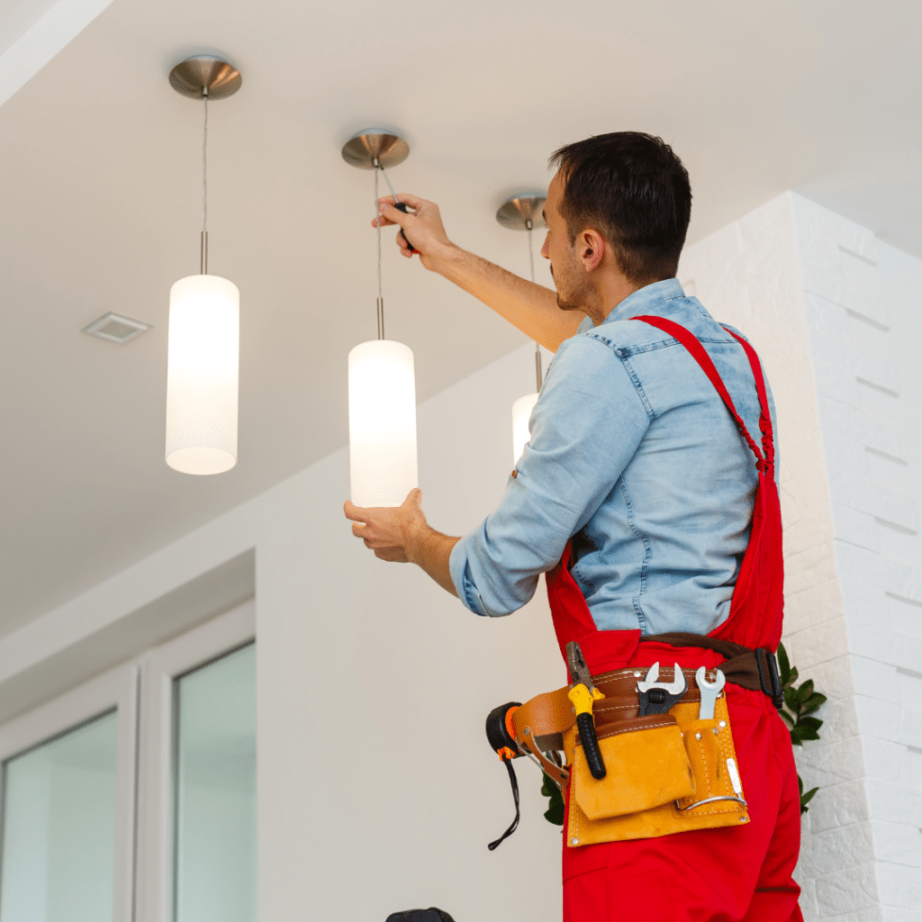 An electrician. is installing a new light fixture.