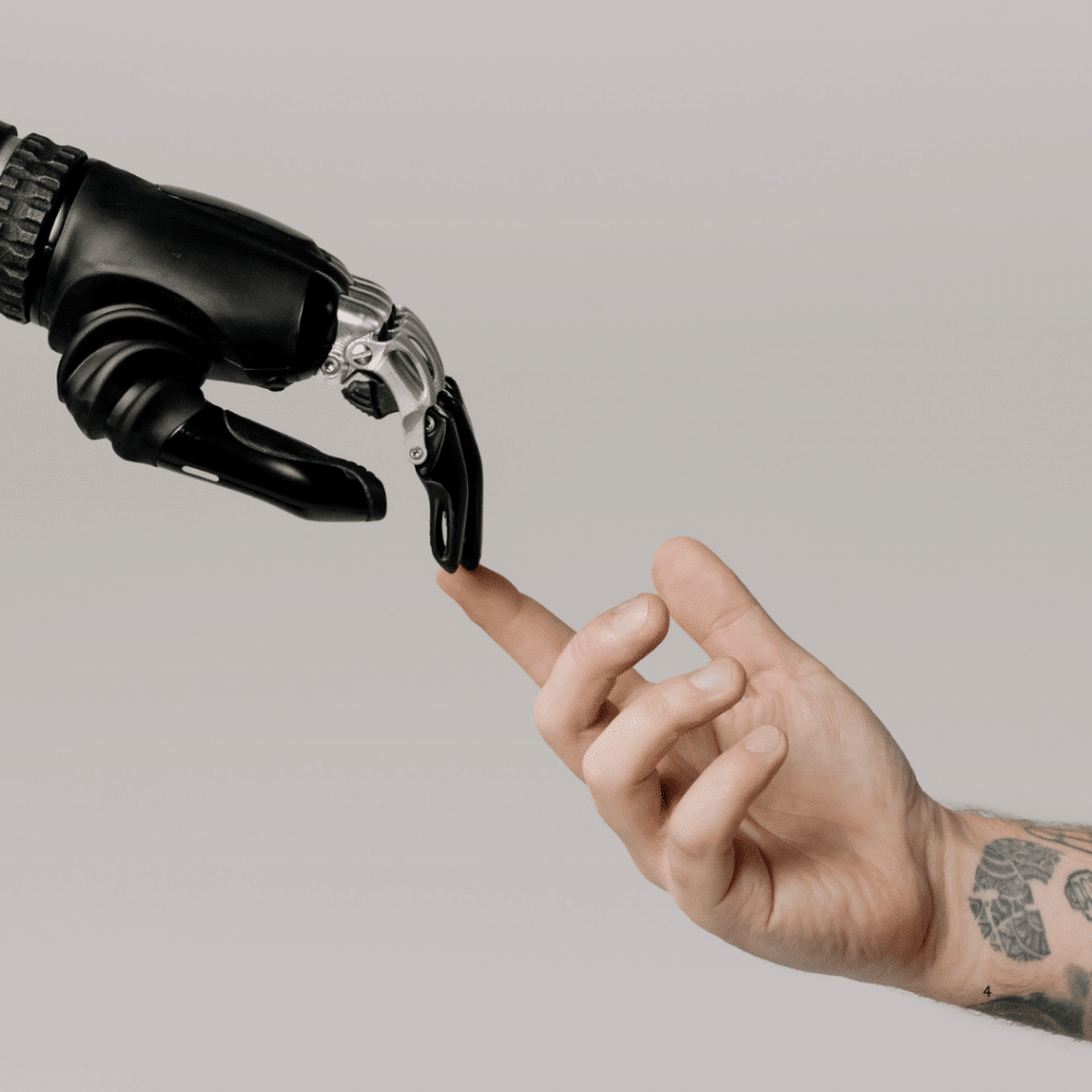 An AI robot hand reaches out to a human male hand in a blog about how to build a small business marketing plan for 2025. 