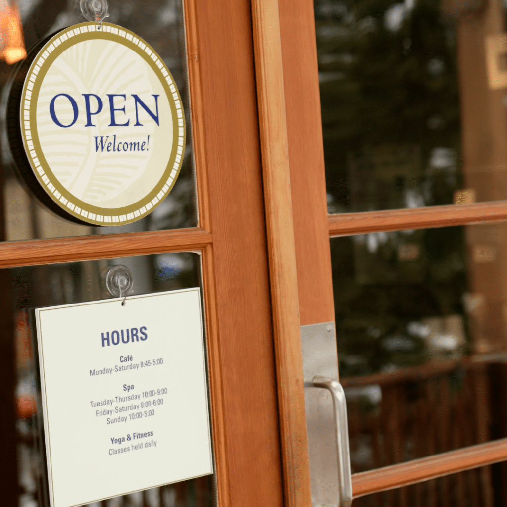 A front door to a small business with an open sign and. hours in a blog about "Local SEO Tips to Dominate Your Market in 2025."